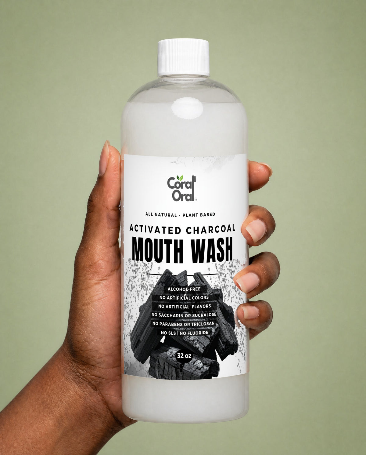 Hand holding Coral Oral Activated Charcoal Mouth Wash 32 oz