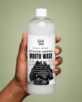 Hand holding Coral Oral Activated Charcoal Mouth Wash 32 oz